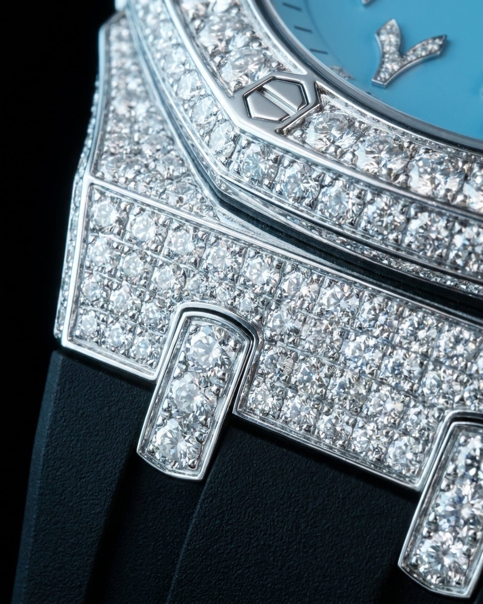 Close-up of a bezel screw and the set octagon bezel beside the blue dial