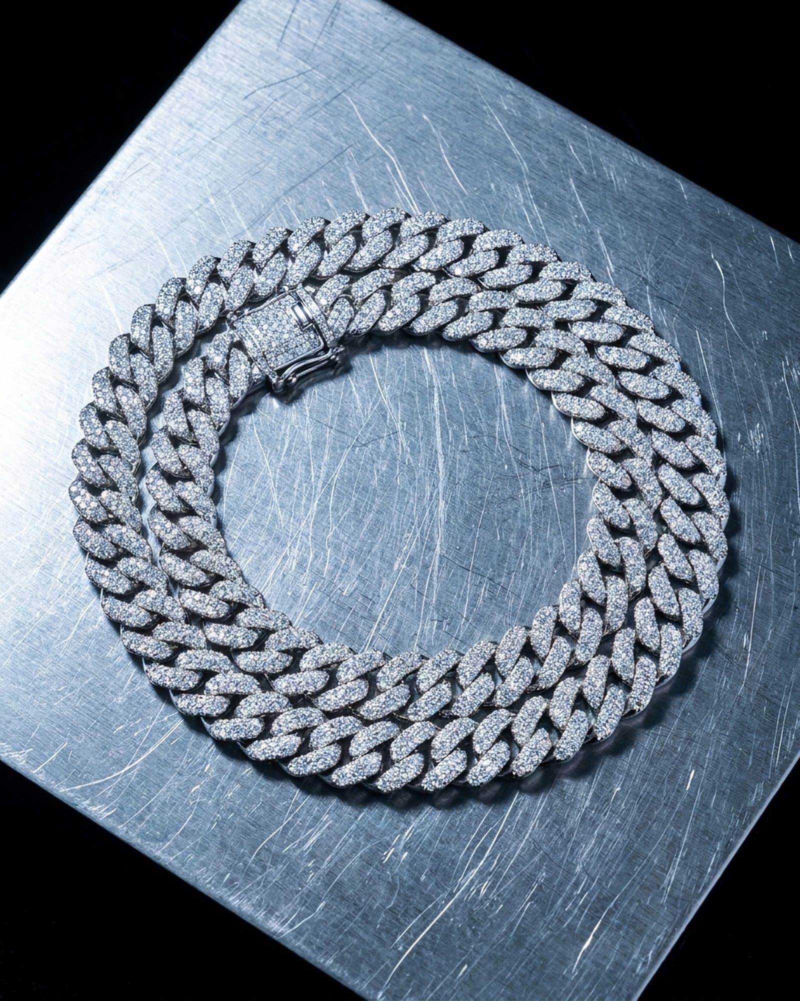 Iced cuban link chain coiled on scratched steel
